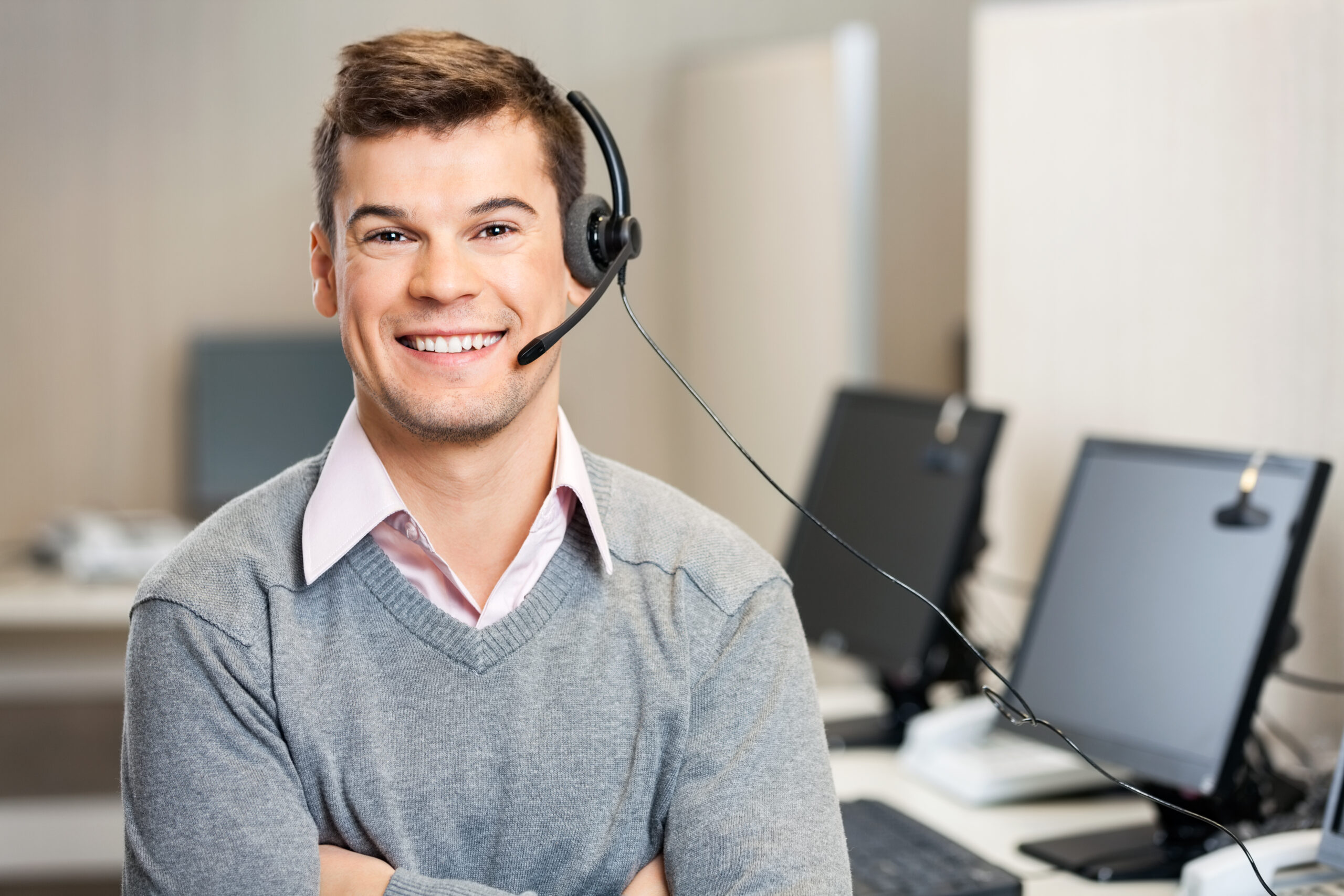 male contact center agent in office smiling ready to start work